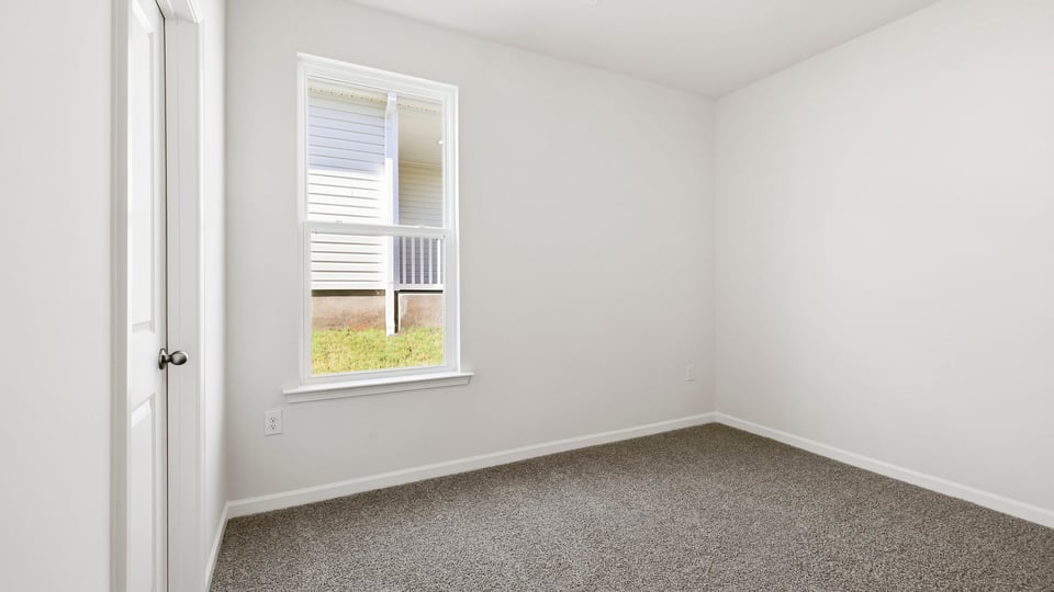 Bedroom with carpet and window.