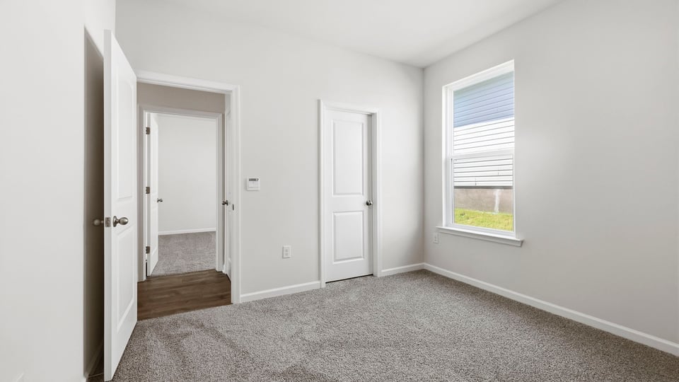 Bedroom with carpet and window.