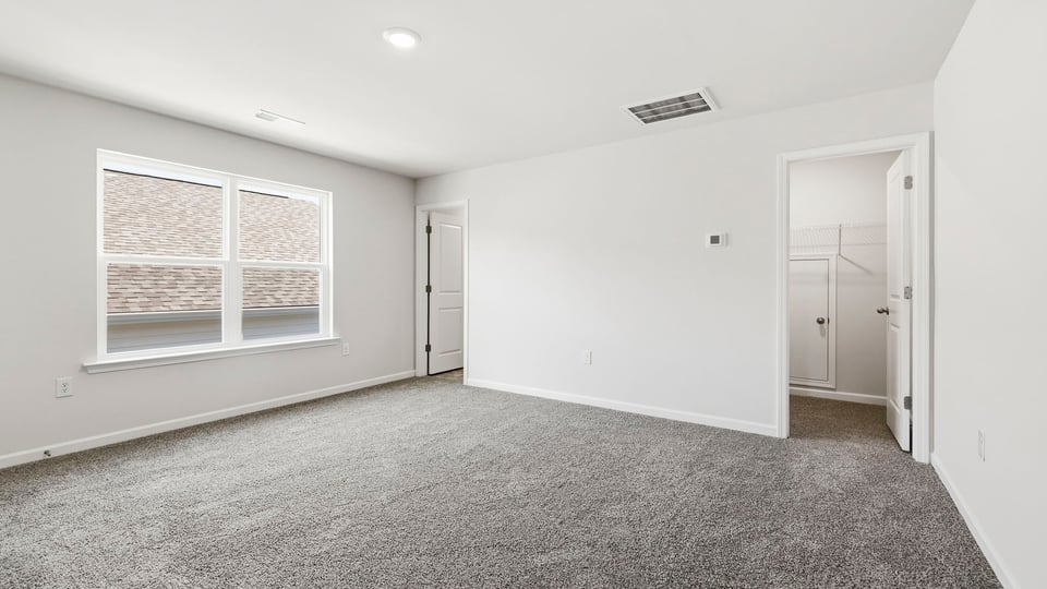 Bedroom with carpet and window.