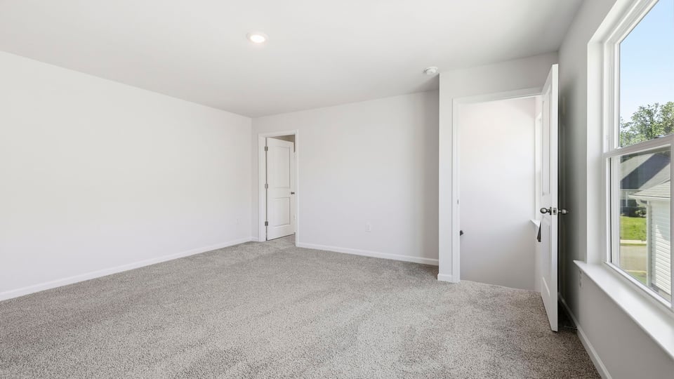 Bedroom with carpet and window.