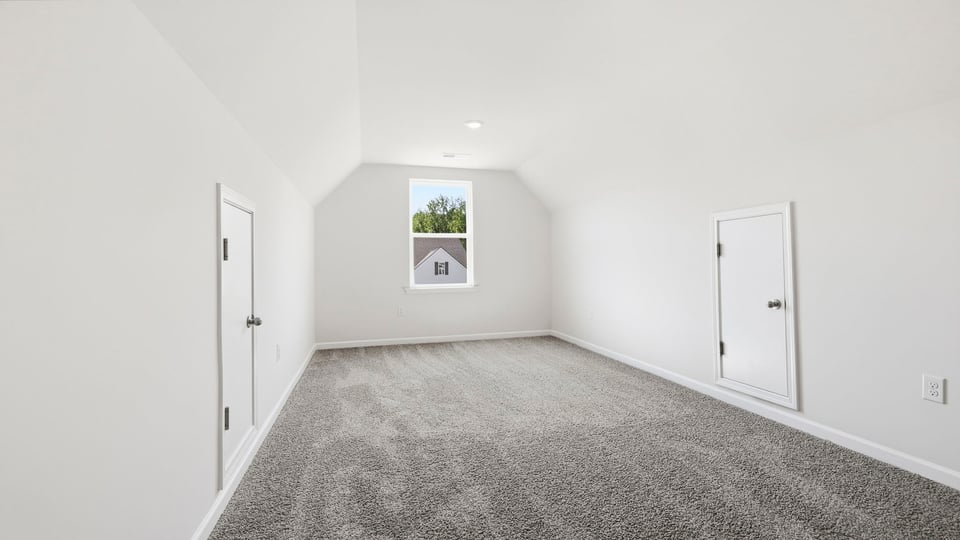 Loft area with carpet and window.