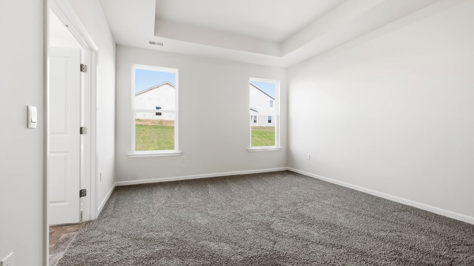 Bedroom with carpet and windows.