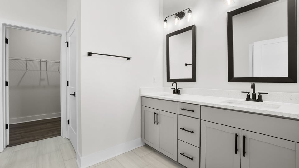Bathroom with double vanity sink and walk in closet.