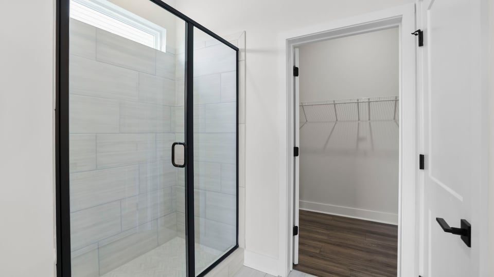 Bathroom with walk in shower and closet.