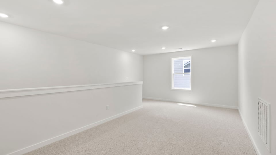 Loft area with carpet and window.