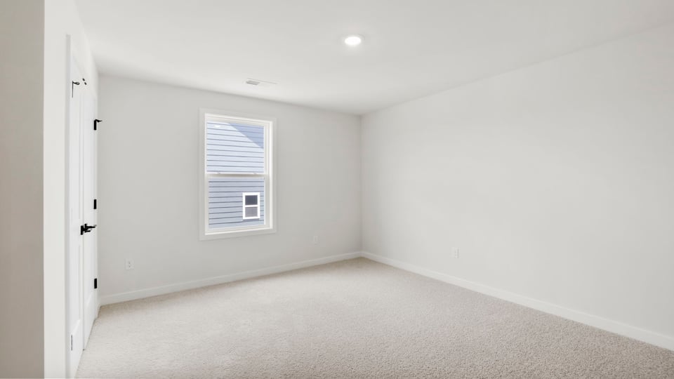 Bedroom with carpet and window.
