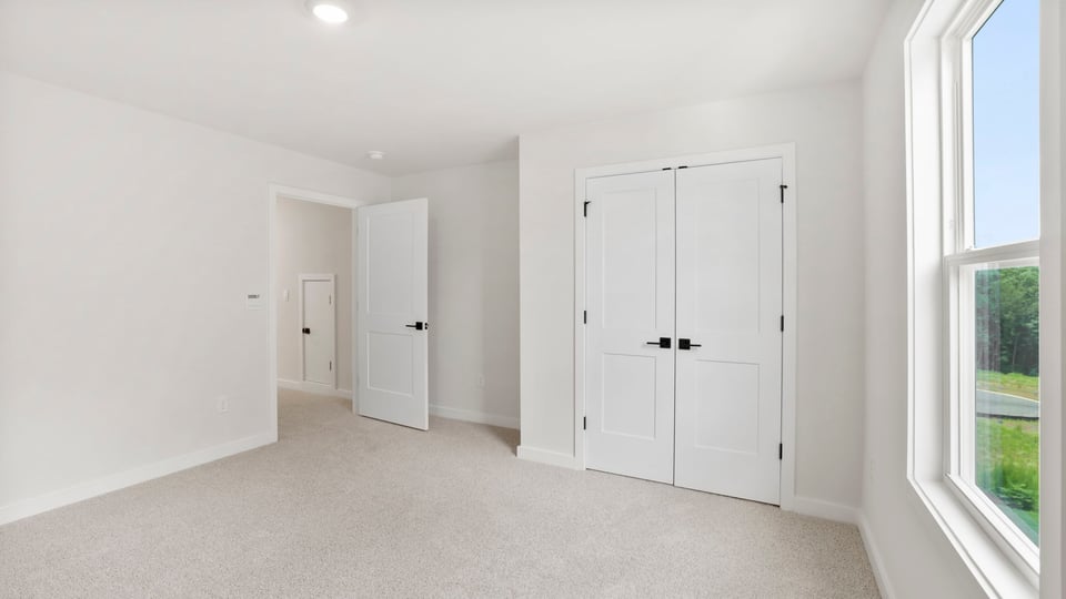 Bedroom with carpet and window.