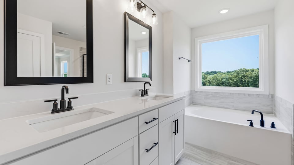 Bathroom with double vanity sink and bathtub.