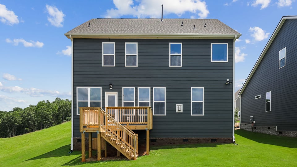 Back exterior of home with large backyard.