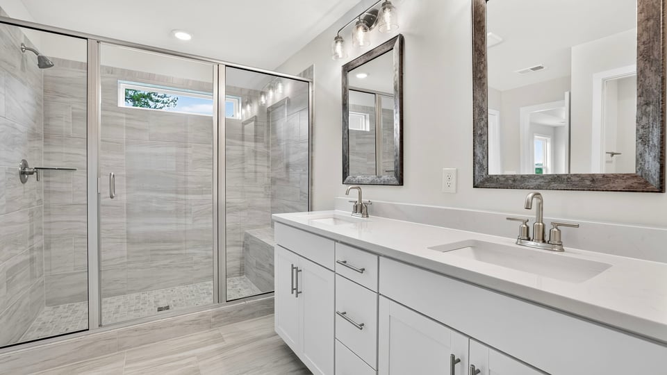 Bathroom with double vanity sink and walk in shower.