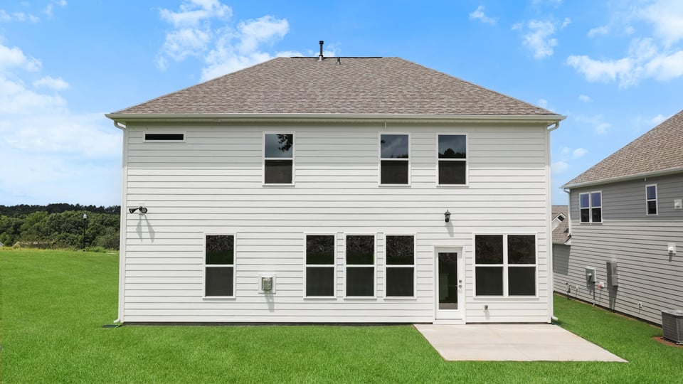 Back exterior of home with large backyard.