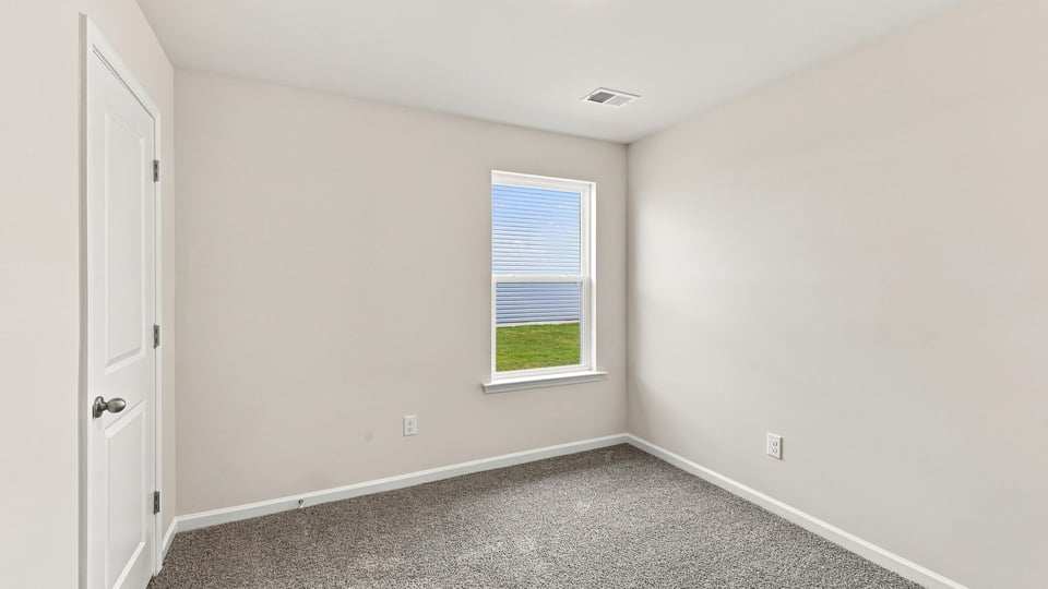 Bedroom with carpet and window.