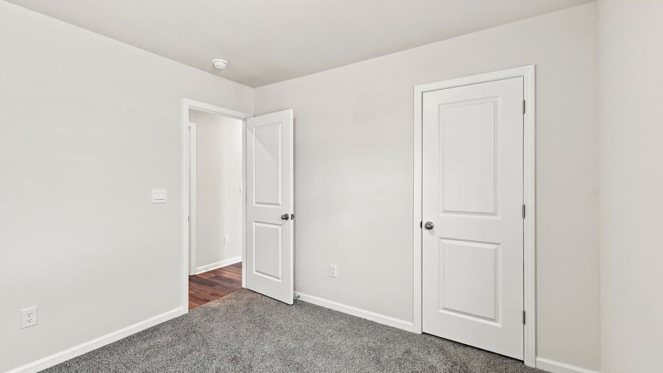 Bedroom with carpet and window.