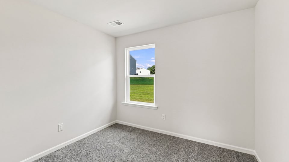 Bedroom with carpet and window.