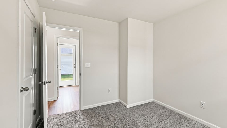 Bedroom with carpet and window.