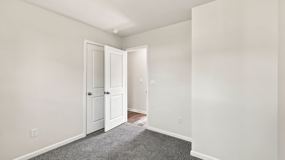 Bedroom with carpet and window.