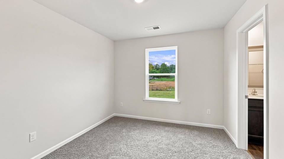 Bedroom with carpet and window.