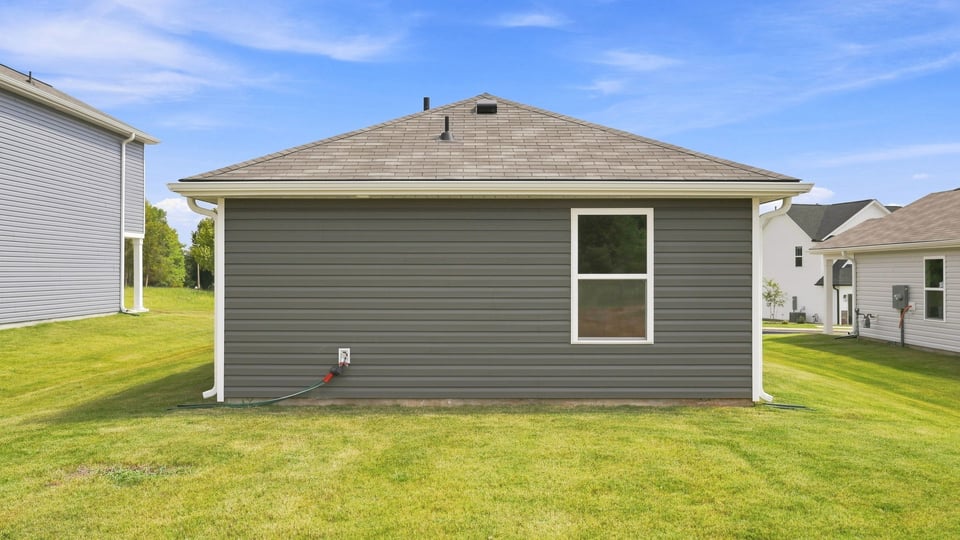 Back exterior of home with large backyard.