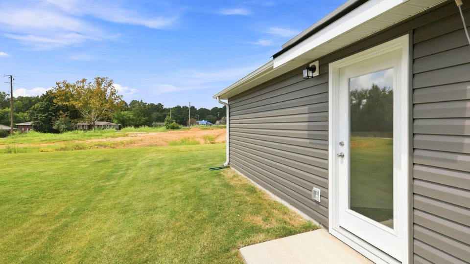Back exterior of home with large backyard.