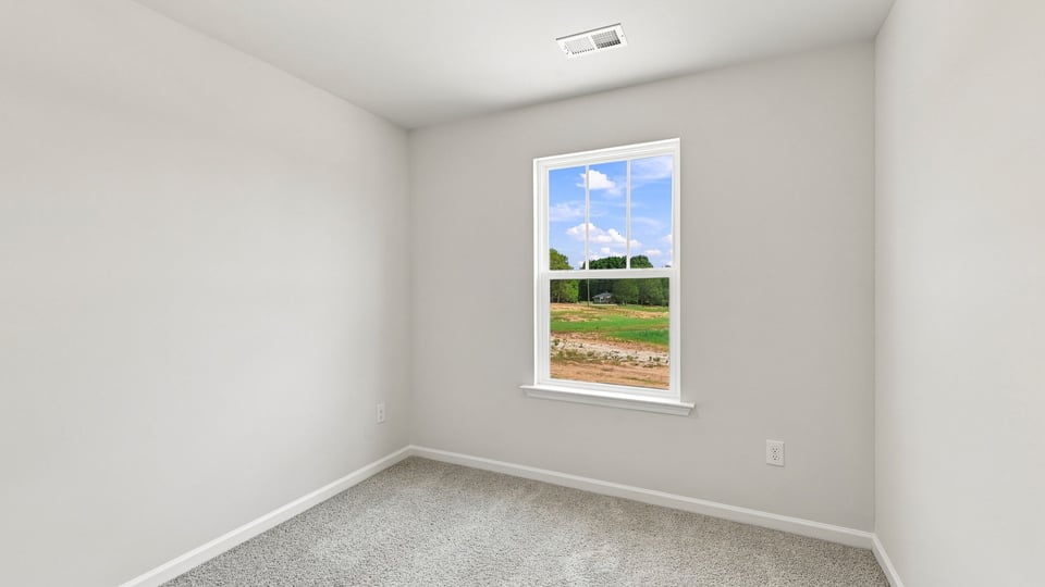 Bedroom with carpet and window.