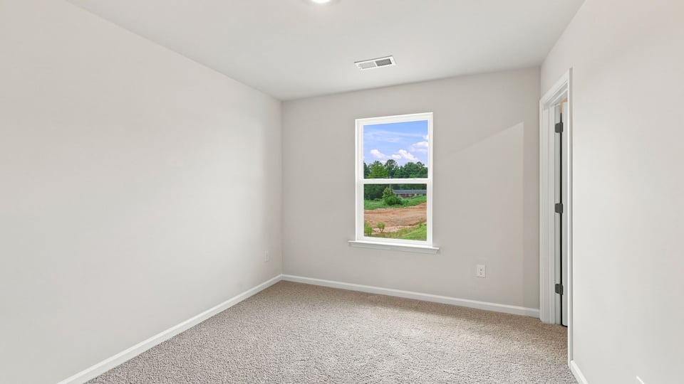 Bedroom with carpet and window.