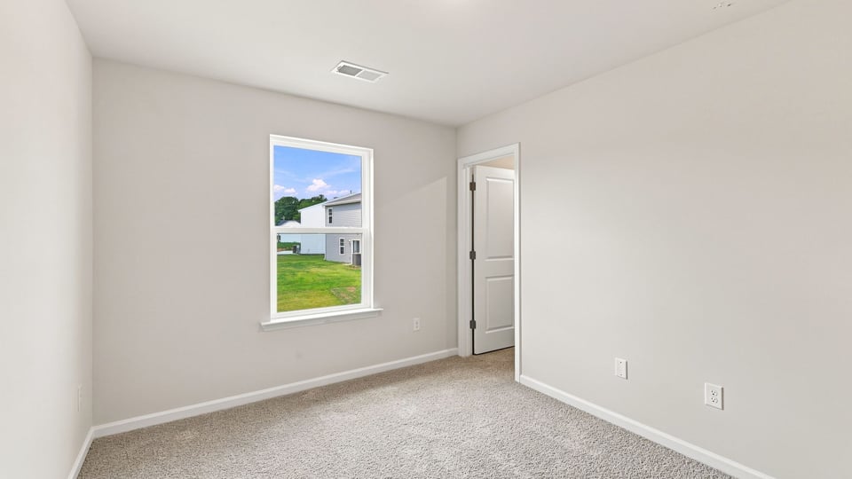 Bedroom with carpet and window.