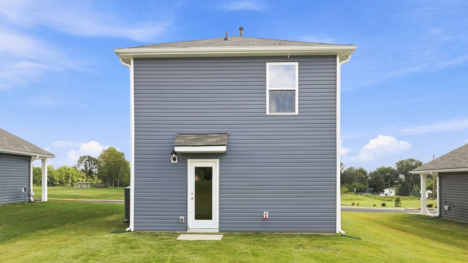 Back exterior of home with large backyard.