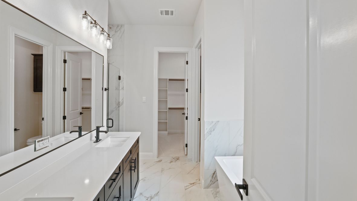 bathroom with dual vanity sinks, toilet, bath tub and a walk in shower