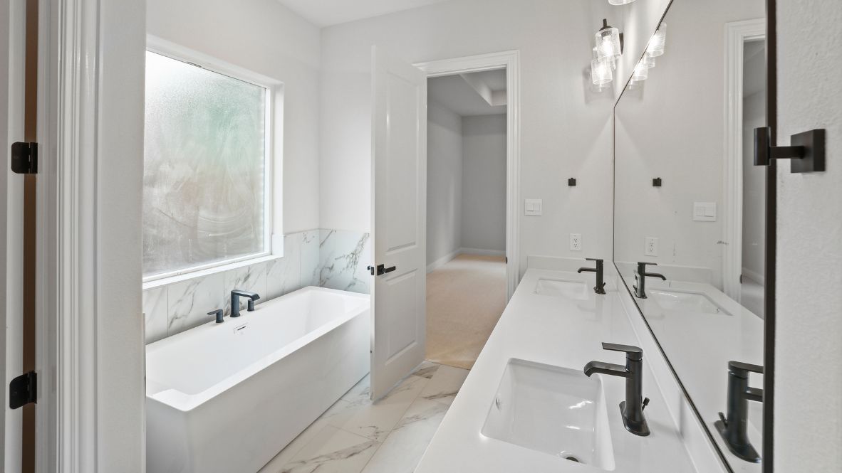 bathroom with dual vanity sinks, toilet, bath tub and a walk in shower