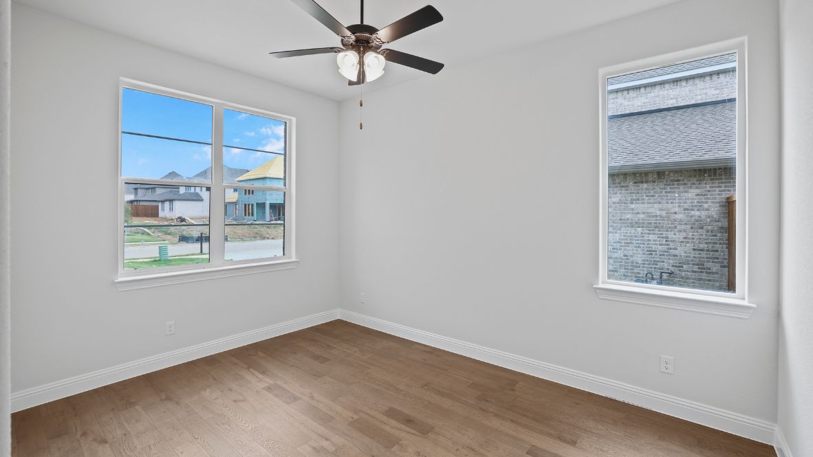 bedroom with brown flooring, white walls and a window