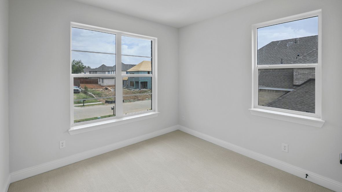 bedroom with beige carpet, grey walls and a window