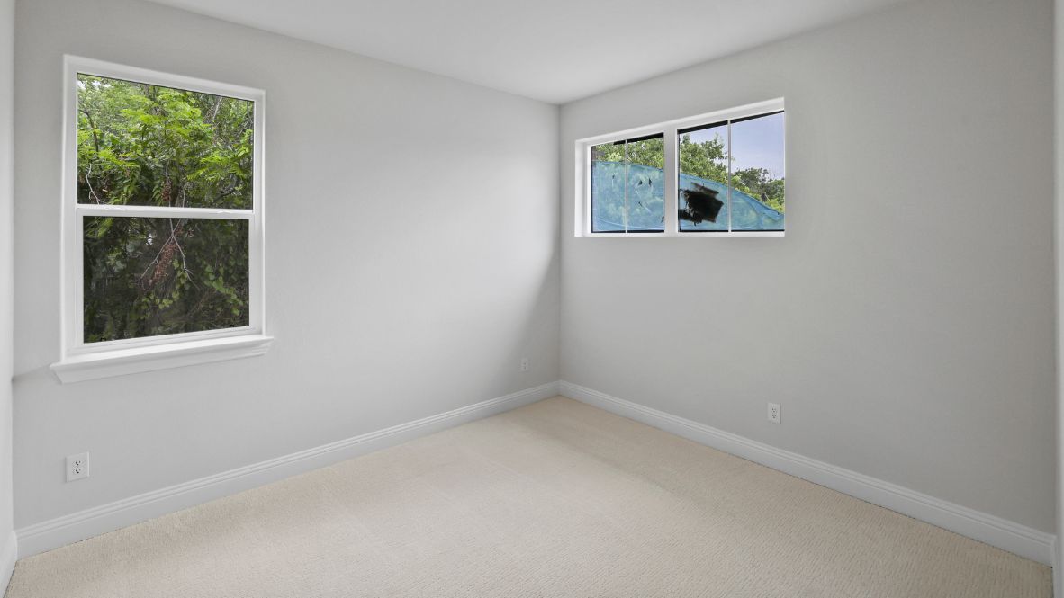 bedroom with beige carpet, grey walls and a window