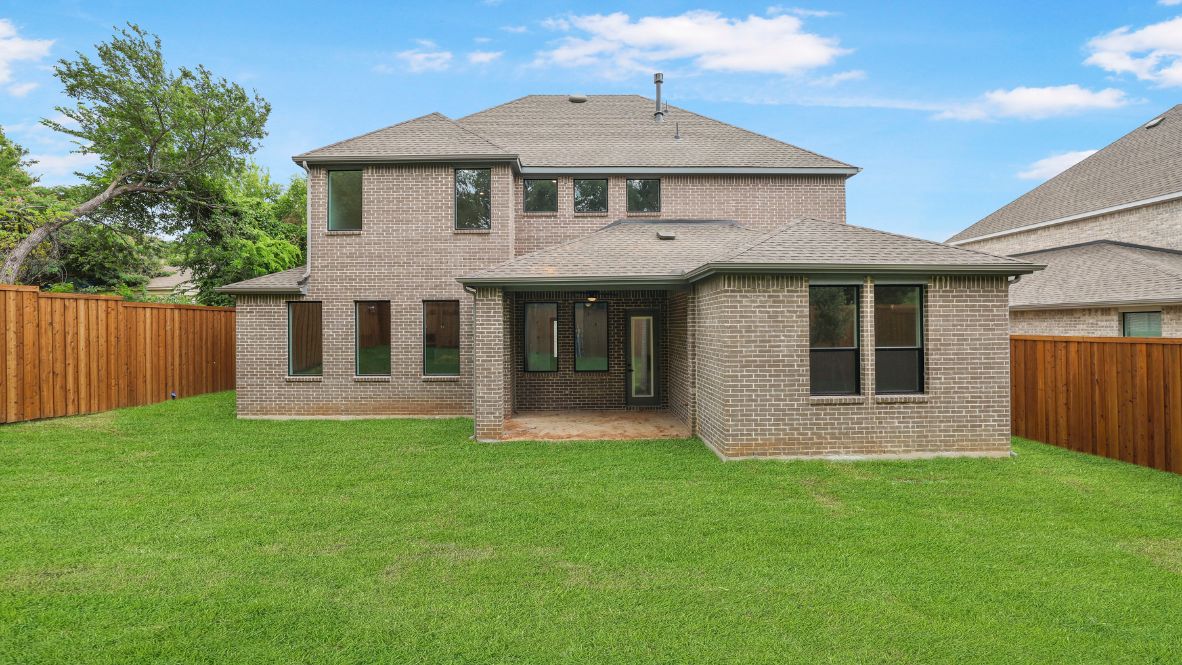 rear exterior of home featuring a spacious fenced in backyard