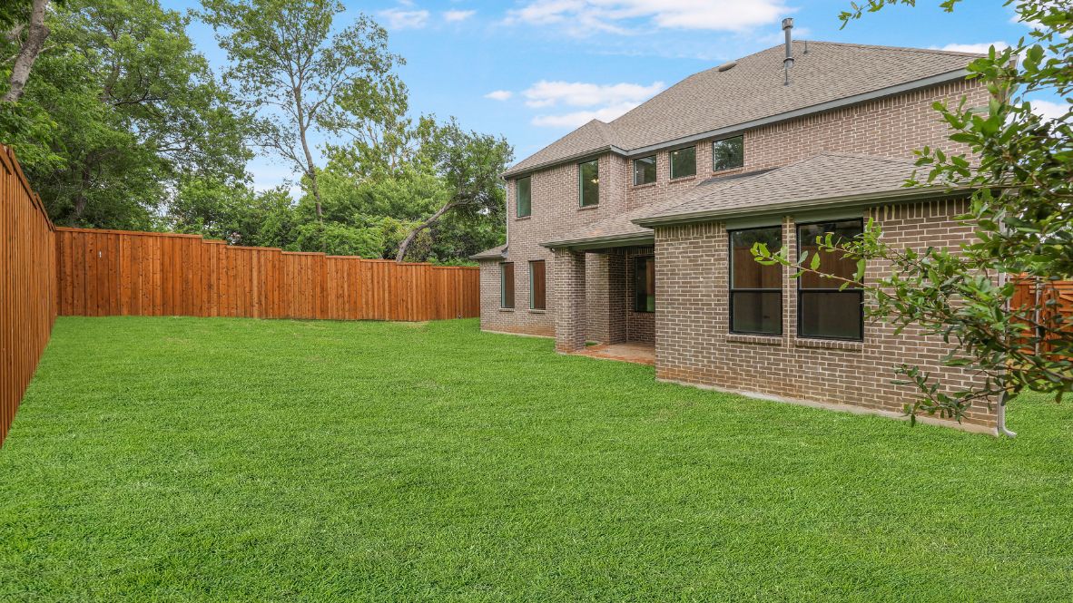 rear exterior of home featuring a spacious fenced in backyard