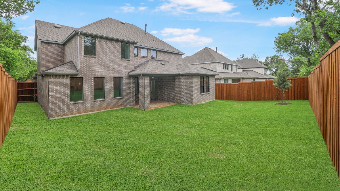 rear exterior of home featuring a spacious fenced in backyard