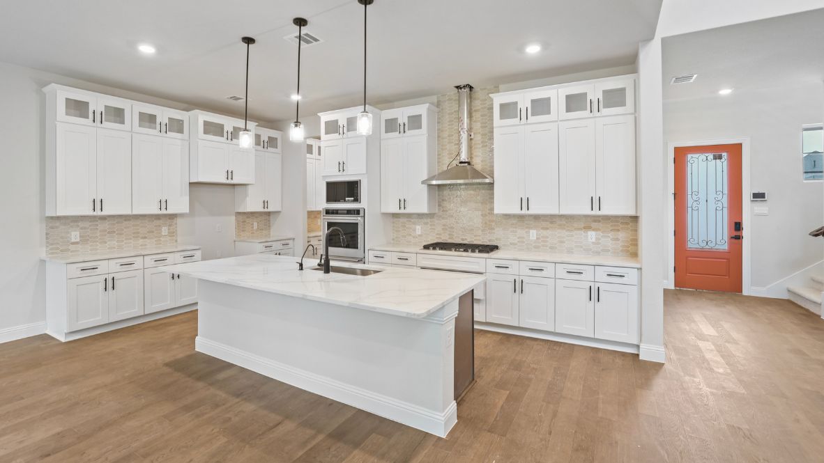 kitchen with white cabinetry, large island, and stainless steel appliances