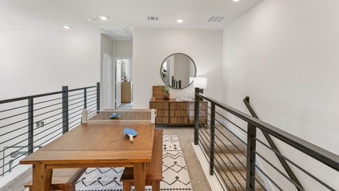 Interior upstairs loft area with overlook and ping pong table