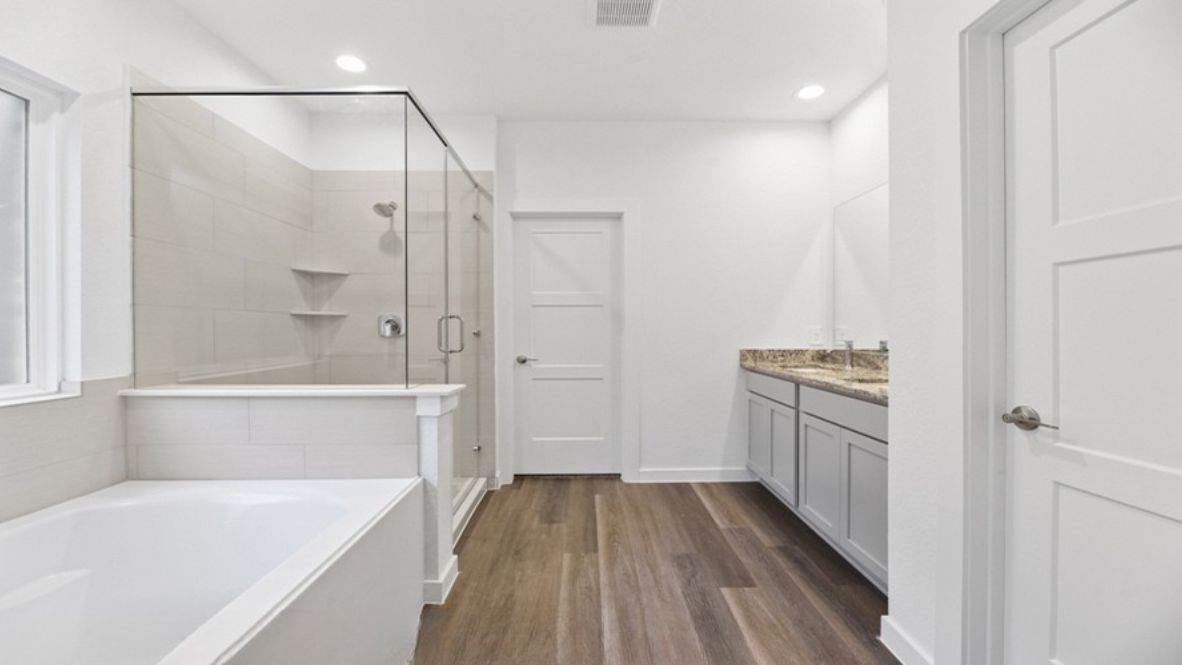 Beyond the living room, you’ll find a private owner’s suite. This retreat is thoughtfully designed with plenty of space for a king-size bed and a sitting area. The en suite bathroom boasts dual vanities, a large walk-in shower, soaking tub, and an expansive walk-in closet with ample storage for your wardrobe.