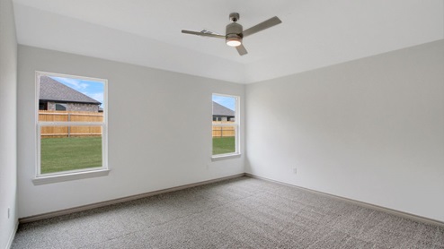 primary suite with carpet and ceiling fan