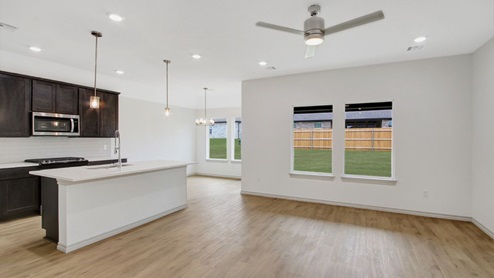 open floor plan with luxury vinyl flooring, large windows and gourmet kitchen