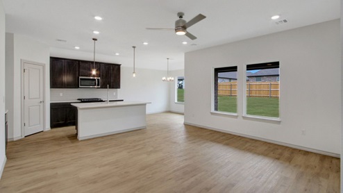 open floor plan with luxury vinyl wood flooring gourmet kitchen space and large windows with natural light