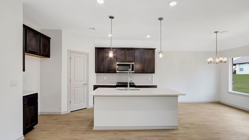 gourmet kitchen with shaker style cabinetry quartz countertops stainless steel appliances and pendants over the island
