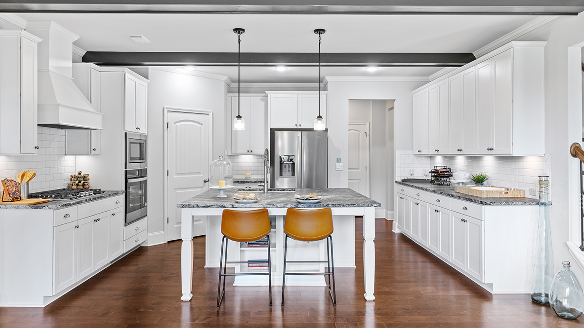 ashley model home kitchen with large island for bar seating and vent hood