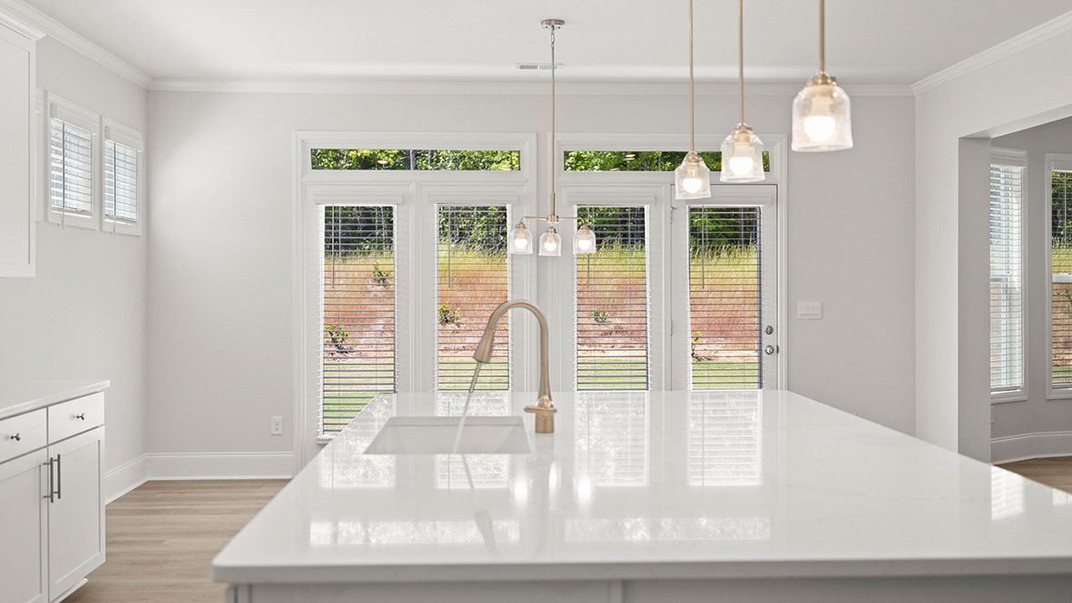 sonoma kitchen with large granite island and white cabinets at genesee in newnan georgia