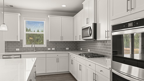sample edinburgh kitchen with white cabinets and double ovens at tributary village in douglasville georgia
