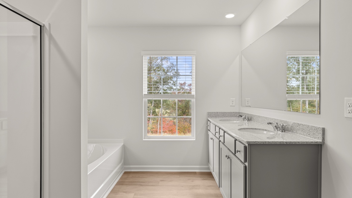 Interior primary bathroom with shower, bath tub and double sink
