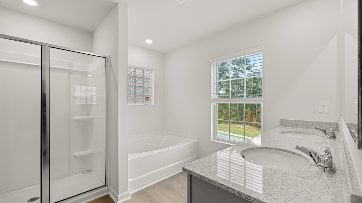 Interior primary bathroom with shower, bath tub and double sink