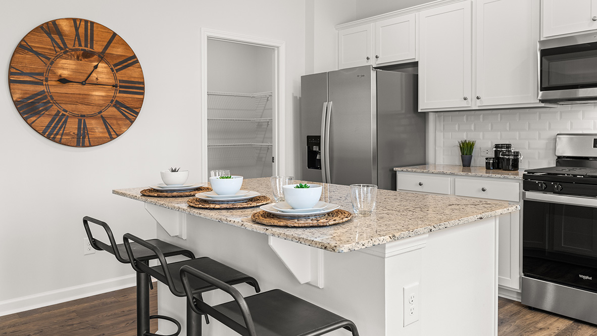 Hanover Plan kitchen with large workspace, upgraded countertops, and open flow to entertainment space by D.R. Horton