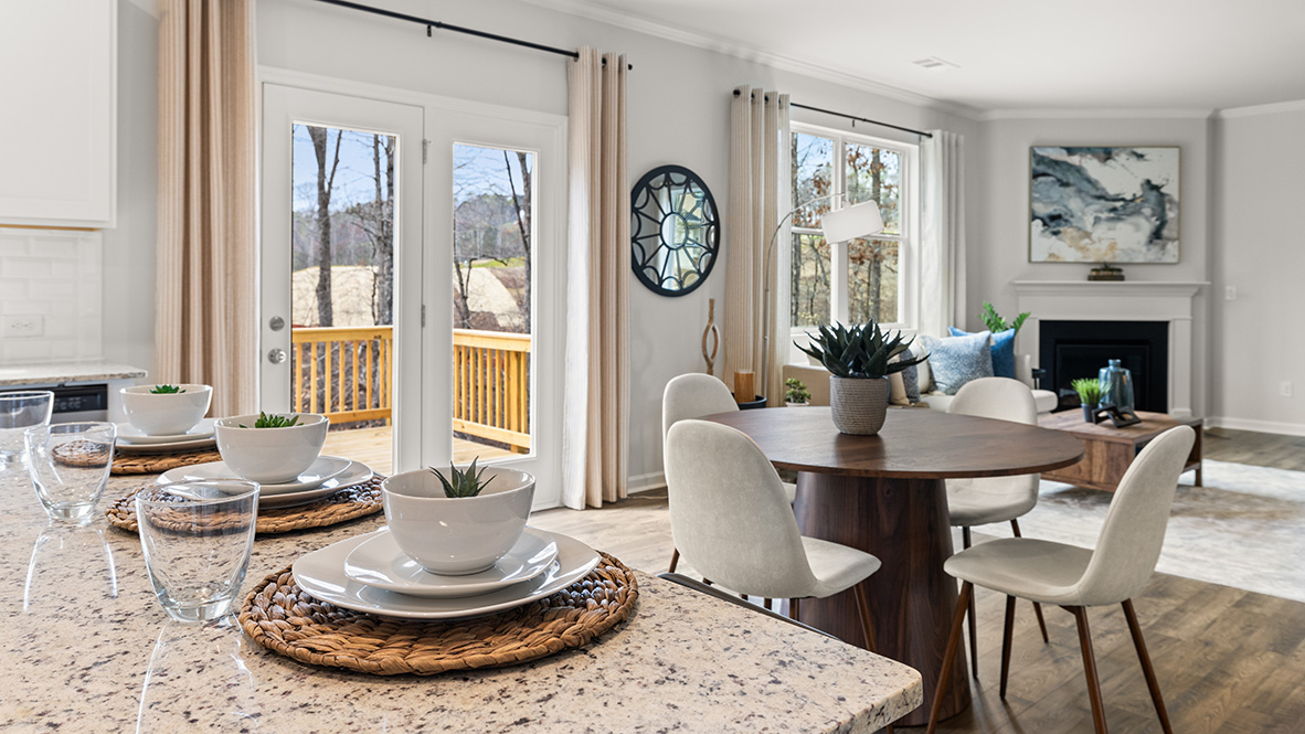 D.R. Horton New Home living room inside Hanover Plan with large windows and continuous sightlines to kitchen