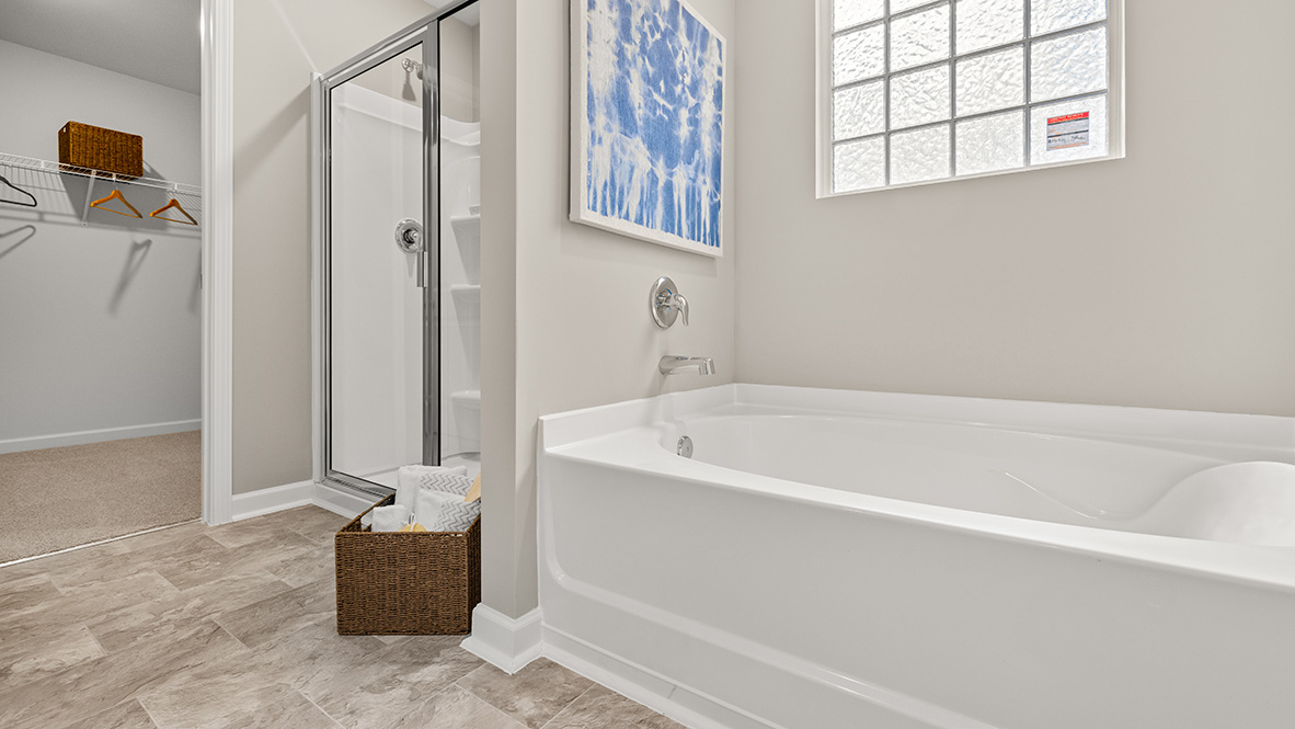 Our Hanover Plan primary bedroom showing restful layout and direct connection to en suite bathroom by D.R. Horton